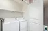 Bright laundry room featuring modern washer and dryer with sleek shelving, perfect for efficient home living.