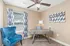 Charming home office with elegant decor, featuring a stylish wood desk, plush blue armchair, and artistic wall accents.