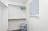 Bright and spacious closet with sleek shelving and modern blinds offering a minimalist and organized storage solution.