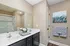 Elegant bathroom featuring a double sink vanity with modern fixtures, sleek dark cabinets, and tasteful artwork.