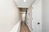 Charming hallway with elegant wooden flooring, stylish white doors, and a decorative wall mirror, offering a welcoming entrance.