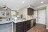 Modern kitchen with sleek granite countertops and stylish cabinetry adjacent to a cozy living area featuring elegant decor.