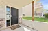 Inviting front entrance with a charming stone accent, featuring a sleek black door and a welcoming doormat, leading into a modern apartment.