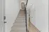 Elegant stairway with plush carpet leading to a modern hallway, showcasing sleek design and bright ambiance.