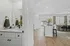 Bright and inviting open-concept layout featuring a modern kitchen island, elegant dining area, and cozy bathroom with sleek finishes.