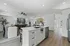 Modern open-concept living space featuring a sleek kitchen island, stylish dining area, and cozy living room with elegant decor.