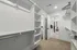 Modern walk-in closet with ample shelving and hanging space, leading to a stylish bedroom.