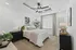 Inviting bedroom with modern ceiling fan, elegant decor, lush plants, and soft lighting creating a serene atmosphere.