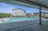 Inviting pool area with modern sun loungers and a scenic view of stylish homes, perfect for relaxation and enjoyment.