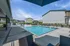 Inviting outdoor pool area with lounge chairs and sunny skyline, perfect for relaxation and leisure.