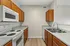 Modern kitchen with sleek countertops, wooden cabinets, and stainless steel fixtures.