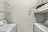 Modern laundry room with sleek white washer and dryer, featuring convenient wire shelving for efficient storage.
