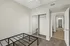 Bright bedroom with mirrored closet doors, modern design, and adjacent bathroom, perfect for comfortable living.
