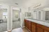 Bright and modern bathroom with dual sinks and mirrors, adjacent to two bedrooms with ample natural light, perfect for comfortable living.