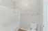 Modern bathroom featuring a sleek bathtub, elegant white tiling, and contemporary fixtures creating a bright and clean atmosphere.