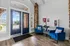 Inviting lobby with elegant brick accents, stylish blue chairs, and a large window offering natural light for a welcoming atmosphere.