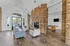 Elegant open-concept living space featuring a cozy stone fireplace, stylish seating area, and a pool table for entertainment.