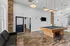 Elegant recreation room boasting a modern pool table, cozy seating on wooden flooring, and stylish hanging lights, perfect for entertainment.