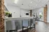 Chic apartment lounge with sleek bar seating, brick accents, and large sunny windows, perfect for relaxation.
