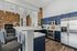 Chic modern kitchen with elegant dark blue cabinetry, stainless steel appliances, and stylish open-concept layout with cozy seating and stone accents.