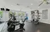 Modern apartment gym with state-of-the-art exercise equipment and natural light.