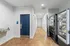 Inviting apartment hallway with sleek tile flooring, a modern vending area, and an accessible restroom door.