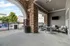 Inviting covered patio with stylish seating, brick accent pillars, and a view of the sparkling pool in a modern apartment complex.