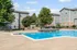 Inviting apartment complex with a sparkling outdoor pool, surrounded by lush greenery and modern architecture, perfect for relaxing and entertaining.