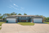 Charming duplex with clean lines featuring twin garages and a welcoming front yard, perfect for modern suburban living.