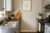 Modern kitchen with sleek gray cabinets, stylish black countertops, and decorative plants for a chic, inviting atmosphere.