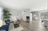 Modern open-concept living space with stylish decor, featuring a cozy living room, sleek kitchen, and a bright dining area with large windows.