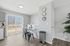 Bright, modern dining space with glass table, chic chairs, and large window offering natural light and serene outdoor views.