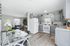 Modern open-plan kitchen and dining area with sleek cabinetry and cozy living room, accented with stylish decor and natural light.