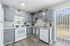 Bright and modern kitchen with sleek grey cabinets, white appliances, and a charming view through sliding glass doors.