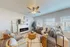 Inviting living room with elegant decor, featuring a cozy sectional sofa, large windows, and a stylish ceiling fan, perfect for relaxation and comfort.