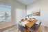 Bright dining area with elegant wooden table set for six, modern decor, and ample natural light from large windows.