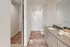 Bright and modern bathroom featuring a sleek shower, elegant granite countertop, and stylish wood flooring.