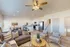 Bright and modern open-concept living area featuring a cozy gray sofa, stylish dining table, and sleek kitchen with stainless steel appliances, complemented by natural light and elegant decor.