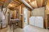 Charming basement laundry room with modern appliances, an ironing station, and convenient storage space.