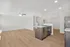 Bright, open-concept living space with sleek hardwood floors, modern kitchen island, and recessed lighting.
