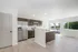 Bright and modern kitchen with sleek cabinetry, stainless steel appliances, and hardwood floors, overlooking serene outdoor views.