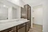 Modern bathroom featuring sleek cabinetry, a polished countertop with sink, and an inviting walk-in closet.