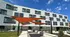 Modern apartment building with striking geometric facade and vibrant orange shade sails under a clear blue sky.