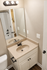 Bright bathroom with elegant vanity, large mirror, and modern lighting for a luxurious feel.