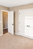Bright and cozy bedroom with plush carpet and elegant white doors, highlighting a modern and inviting space.