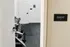 Contemporary fitness room entry with stylish dumbbell rack and sleek flooring for a modern workout experience.