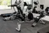 Modern fitness center featuring state-of-the-art exercise equipment, including treadmills and rowing machines, with large mirrors and natural lighting.