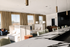 Elegant and spacious living area with modern decor, featuring luxurious seating, ambient lighting, and large windows with floor-to-ceiling drapes.