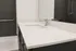 Modern bathroom with sleek white countertop, elegant faucet, and spacious mirror, offering a luxurious experience.