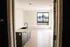 Bright, modern apartment featuring an open-concept kitchen with a sleek island, large window with scenic views, and inviting natural light.